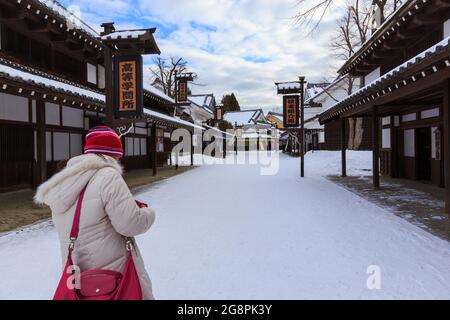 Otaru, Japan-Dezember 22,2017: Asiatische chinesische junge Dame Tourist aus ist in Noboribetsu Datum JIdaimura Historic Village Aufnahme im Winter Stockfoto