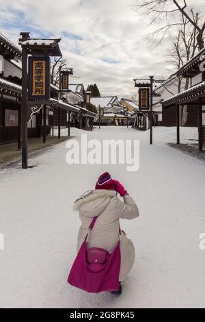 Otaru, Japan-Dezember 22,2017: Asiatische chinesische junge Dame Tourist aus ist in Noboribetsu Datum JIdaimura Historic Village Aufnahme im Winter Stockfoto