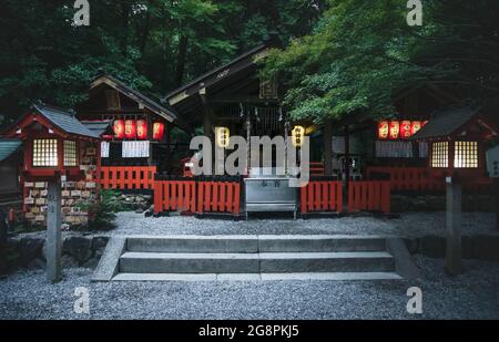 Kyoto, Japan - 18. September 2017: Der Nonomiya-Schrein am Abend mit erleuchteten Laternen, umgeben von üppigem Wald Stockfoto