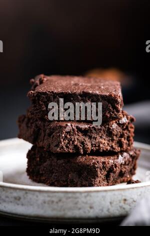 Stapel von reichen Schokolade Brownies auf einem Teller, schwarzer Hintergrund mit Kopierplatz Stockfoto