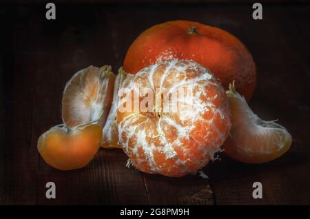 Mandarinen in Masse auf einem groben Stoff, in einem dunklen rustikalen Stil Stockfoto