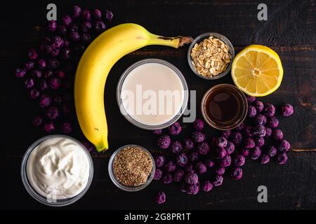 Gesunde Blaubeer Muffin Frühstück Smoothie Zutaten: Rohe Smoothie Zutaten einschließlich gefrorener Heidelbeeren, Bananen und Haferflocken Stockfoto