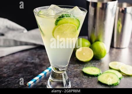 Weißer Leinencocktail mit Gurke und Lime Garnish: Ein Gin-Cocktail aus Holunderblütenlikör und Limettensaft Stockfoto