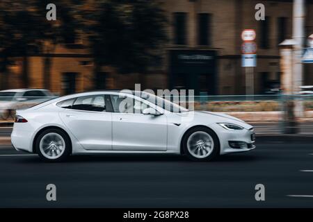 Ukraine, Kiew - 16. Juli 2021: Weißes TESLA Model S Auto bewegt sich auf der Straße. Redaktionell Stockfoto