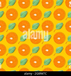 Collage moderner Kunst. Saftige Scheiben aus orangefarbenen und kleinen grünen Blättern, die in geraden Reihen auf hellgelbem Hintergrund angeordnet sind. Stockfoto