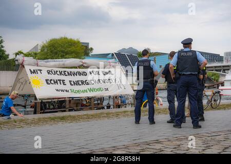 Berlin, Deutschland. 22 2021. Juli: Polizisten stehen im Regierungsbezirk bei einem Floß der Umweltschutzorganisation Robin Wood. Die Aktivisten fordern eine "echte" Energiewende. Die Polizei stoppte zunächst die Fahrt der Sparren, weil sie angeblich auf verbotene Weise im Regierungsviertel angedockt hatten. Das Problem wurde nach langer Diskussion und mit viel Geduld gelöst. Am Freitag startet die Organisation eine dreiwöchige Floßtour von Berlin nach Hamburg. Foto: Paul Zinken/dpa Kredit: dpa picture Alliance/Alamy Live News Stockfoto