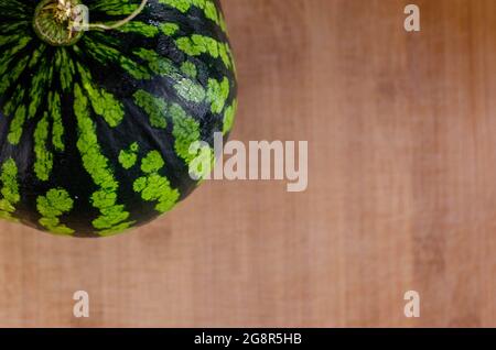 Eine frische, reife Wassermelone auf einem Holzbrett. Fruchtkonzept zum sommerlichen Essen Stockfoto