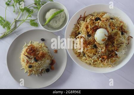 Hausgemachtes Huhn biriyani serviert mit Stachelbeerpickel. Gedämpfter Basmati-Reis, geschichtet mit würziger Soße aus entbeintem Huhn auf Joghurtbasis, karamellisiert Stockfoto