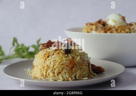 Hausgemachtes Huhn biriyani. Gedämpfter Basmati-Reis, geschichtet mit würziger Soße auf Joghurtbasis aus entbeintem Huhn, karamellisierten Zwiebeln und gebratenen Cashew-Nüssen Stockfoto