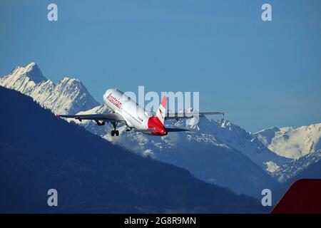 INNSBRUCK, ÖSTERREICH - 22. Feb 2020: Abflug des österreichischen Airbus A320 mit schneebedeckten Bergen im Hintergrund Stockfoto