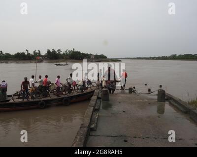 KALKUTTA, INDIEN - 30. Jun 2021: Sunderbans, Westbengalen, Indien - Holzboote helfen den Einheimischen, von einer Seite des Flusses auf die andere am Ufer zu fahren Stockfoto