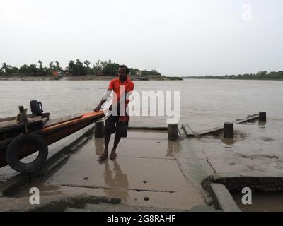 KALKUTTA, INDIEN - 30. Jun 2021: Fischer, die ein orangefarbenes Boot im Hafen ankern: Sunderban-Indien. Stockfoto