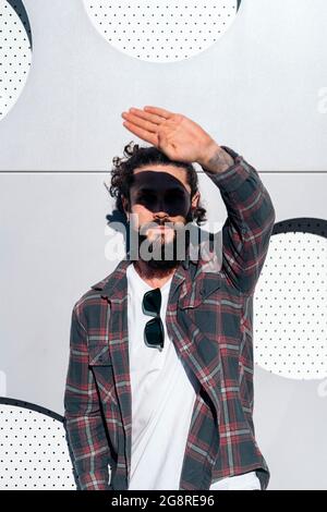 Hübscher Hipster-Mann posiert und schaut vor weißem Hintergrund auf die Kamera. Stockfoto