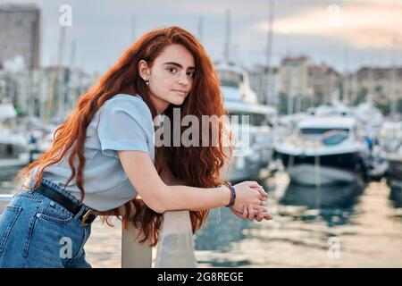 Porträt einer jungen Rotschopf-Frau in einem Hafen einer Stadt Stockfoto