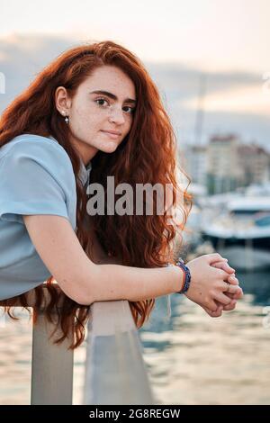 Porträt einer jungen Rotschopf-Frau in einem Hafen einer Stadt Stockfoto