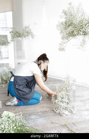 Frau Floristen Dekorateurin schmückt Hochzeit Interieur mit Blumen Stockfoto