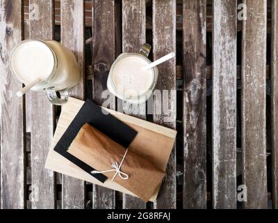 Zwei Tassen Eis Cappuccino und Rollen auf einem Holztisch in einem Café Stockfoto