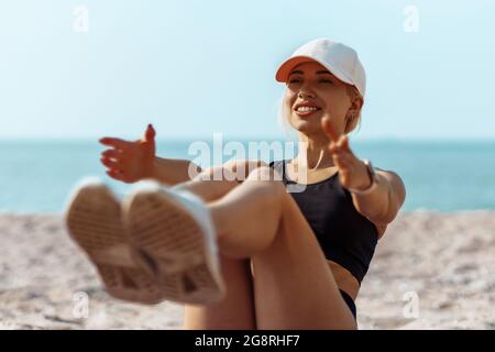 Sport junger Athlet auf einer Yoga-Matte, mit einem schlanken Körper, arbeiten an der Presse, auf dem Boden liegen, Training der Presse am Strand bei Sonnenaufgang Stockfoto