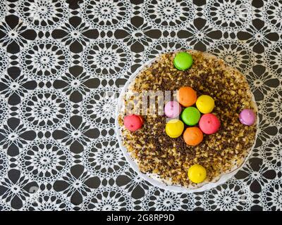 Hausgemachter Kuchen auf einem Tisch, der mit einer schönen Tischdecke bedeckt ist. Das Konzept der Herstellung von kulinarischen Produkten mit Familienmitgliedern. Stockfoto