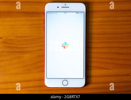 Estremadura. 07, 22, 2021. Overhead-Aufnahme eines iPhone mit der Slack-App auf dem Bildschirm. Arbeits- und Zeitmanagement-App Stockfoto