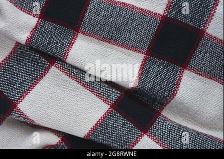 Detail einer schwarz, weiß und blau karierten Decke mit roten Streifen Stockfoto