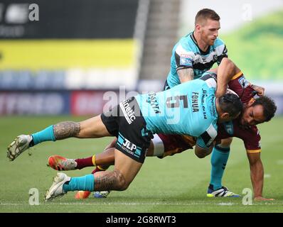 Leroy Cudjoe von Huddersfield Giants wird von Mahe Fonua (links) und Marc Sneyd (rechts) des Hull FC während des Matches der Betfred Super League im John Smith's Stadium, Huddersfield, angegangen. Bilddatum: Donnerstag, 22. Juli 2021. Stockfoto