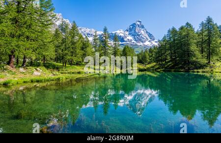 Idyllischer Morgenblick auf den Blauen See mit dem Matterhorn, das auf dem Wasser reflektiert, Valtournenche, Aostatal, Italien. Stockfoto