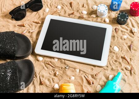 Online-Poker-Spiel am Strand mit digitalen Tablet und Stapel von Chips. Draufsicht Stockfoto
