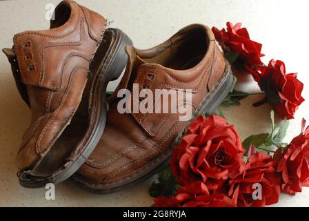 Alte Schuhe, Löcher in Schuhen und Rosen, Rosen, weihnachtsbaum, Stockfoto