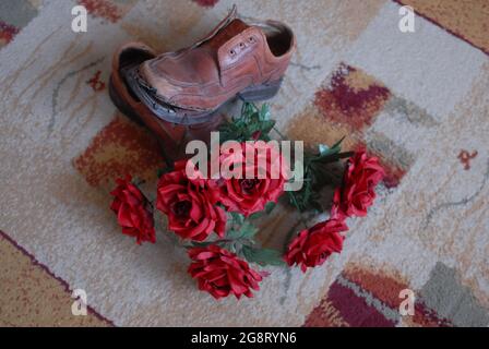 Alte Schuhe, Löcher in Schuhen und Rosen, Rosen, weihnachtsbaum, Stockfoto