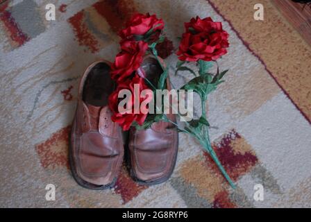 Alte Schuhe, Löcher in Schuhen und Rosen, Rosen, weihnachtsbaum, Stockfoto