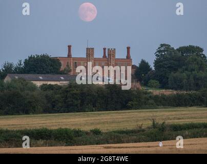 Eastchurch, Kent, Großbritannien. Juli 2021. UK Wetter: Der fast Vollmond, der heute Abend über der Shurland Hall in Eastchurch, Kent, aufsteigt. Kredit: James Bell/Alamy Live Nachrichten Stockfoto