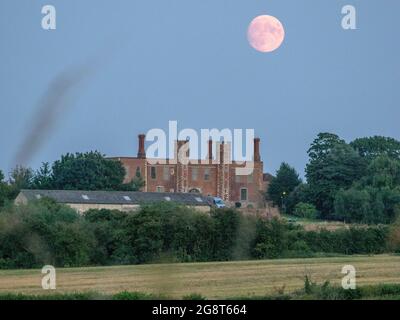 Eastchurch, Kent, Großbritannien. Juli 2021. UK Wetter: Der fast Vollmond, der heute Abend über der Shurland Hall in Eastchurch, Kent, aufsteigt. Der volle Buck-Mond wird in den nächsten Tagen sichtbar sein. Kredit: James Bell/Alamy Live Nachrichten Stockfoto