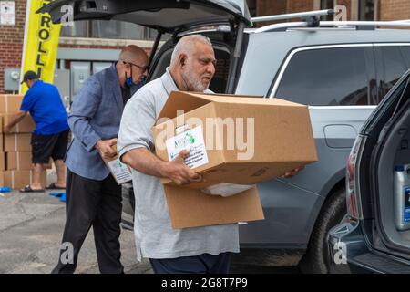 Detroit, Michigan, USA. Juli 2021. Mitglieder des muslimischen Gemeinderats von Michigan laden während des Eid al-Adha-Feiertags Lammpakete zur Verteilung an die Armen aus. Eid al-Adha erinnert an die gemeinsame Geschichte von Muslimen und Christen, in der Gott Ibrahim (Abraham) bat, seinen Sohn zu opfern, aber in letzter Minute stattdessen ein Lamm ersetzte. Während des Urlaubs schlachten Muslime ein Lamm, halten einen Teil des Fleisches und spenden den Rest an alle in Not. Kredit: Jim West/Alamy Live Nachrichten Stockfoto