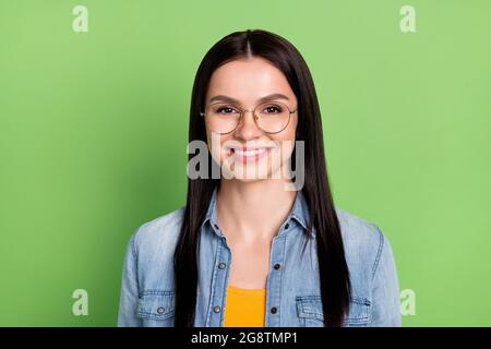 Foto von optimistisch schöne braune Frisur Dame tragen Brille Jeans Hemd isoliert auf grünem Hintergrund Stockfoto