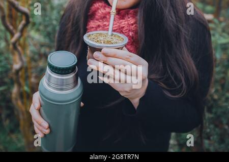 Junge Frau trinkende Mate im Park. Lateinisches Getränk. Stockfoto