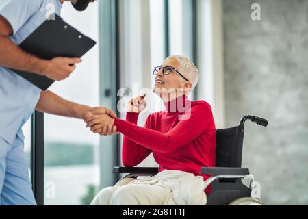 Ältere Frau im Rollstuhl, die von einem Arzt gesehen wird Stockfoto