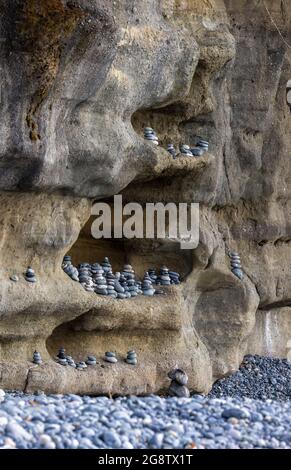 Mehrere ausgewogene Felsen in einer erodierten Felswand am French Beach Stockfoto