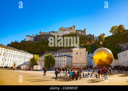 Kapitelplatz mit einer Skulptur eines Mannes auf einer goldenen Kugel in der Stadt Salzburg. Aufgenommen in Salzburg, Österreich, 20. Oktober 2016 Stockfoto