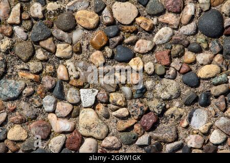 Draufsicht Nahaufnahme Textur Hintergrund einer Vintage ausgesetzt Aggregat Stein Terrasse Oberfläche in hellem natürlichem Sonnenlicht Stockfoto