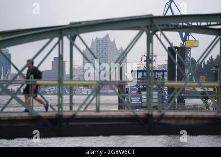 Hamburg, Deutschland. Juli 2021. Ein Passant spaziert über den Steg am Fischmarkt-Fährhafen im Hafen. Kredit: Marcus Brandt/dpa/Alamy Live Nachrichten Stockfoto