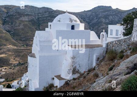 Kirche orthodox mit Kreuz, kleine weiß gewaschene verwitterte alte Struktur, kletterte auf felsigen Berg bei Serifos Insel, Kykladen Griechenland. Religiöser destin Stockfoto