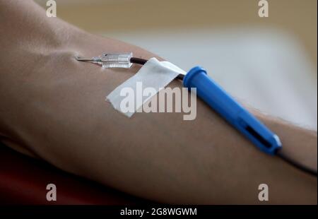 Rostock, Deutschland. Juli 2021. Blut wird im Blutspendezentrum des Universitätsklinikums gespendet. Das Universitätsklinikum richtet sich an die Bevölkerung mit einem Appell, der um Blutspenden bittet. Aufgrund des akuten Mangels an Blutspenden müssen die Operationen jeden Tag verschoben werden, die Corona-Krise hat den Blutmangel, der für einen Sommer normal ist, auf das Maximum verschärft. Quelle: Bernd Wüstneck/dpa-Zentralbild/ZB/dpa/Alamy Live News Stockfoto