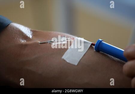 Rostock, Deutschland. Juli 2021. Blut wird im Blutspendezentrum des Universitätsklinikums gespendet. Das Universitätsklinikum richtet sich an die Bevölkerung mit einem Appell, der um Blutspenden bittet. Aufgrund des akuten Mangels an Blutspenden müssen die Operationen jeden Tag verschoben werden, die Corona-Krise hat den Blutmangel, der für einen Sommer normal ist, auf das Maximum verschärft. Quelle: Bernd Wüstneck/dpa-Zentralbild/ZB/dpa/Alamy Live News Stockfoto