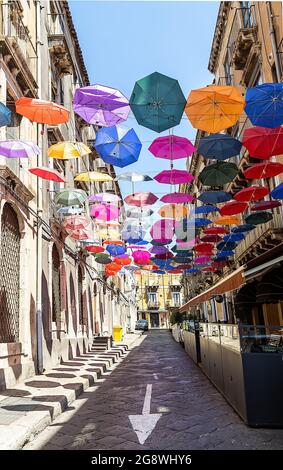 Die Straße ist mit farbigen Sonnenschirmen dekoriert. Catania, Sizilien. Stockfoto