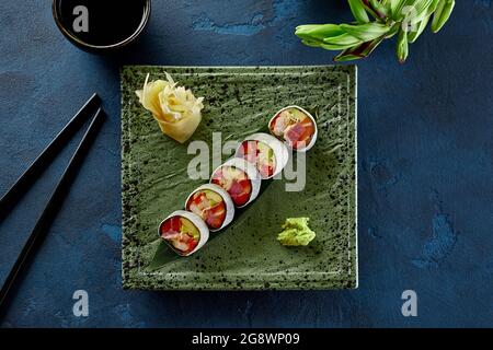 Sushi-Rollen mit Thunfisch, Lachs, Krabben, Tobiko und Avocado in den Mamenori Stockfoto