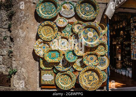Erice, Sizilien - 8. Juni 2021. Farbenfrohe, handgedekorierte Keramik. Traditionelles touristisches Suvenir. Straßenverkäufer mit handgefertigten Handwerken.Teller mit Ornamenten Stockfoto