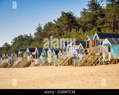 29. Juni 2019: Wells-Next-the-Sea, Norfolk, England, UK - Badehütten am Strand, Bäume dahinter. Stockfoto