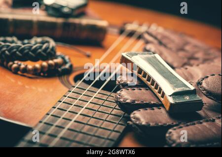Vintage Holzharmonika, die auf einer alten Akustikgitarre liegt. Stockfoto