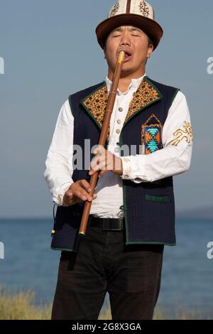 Kirgisischer Musiker, der traditionelle Flöte spielt, in Issyk Kul, Kirgisistan. Stockfoto